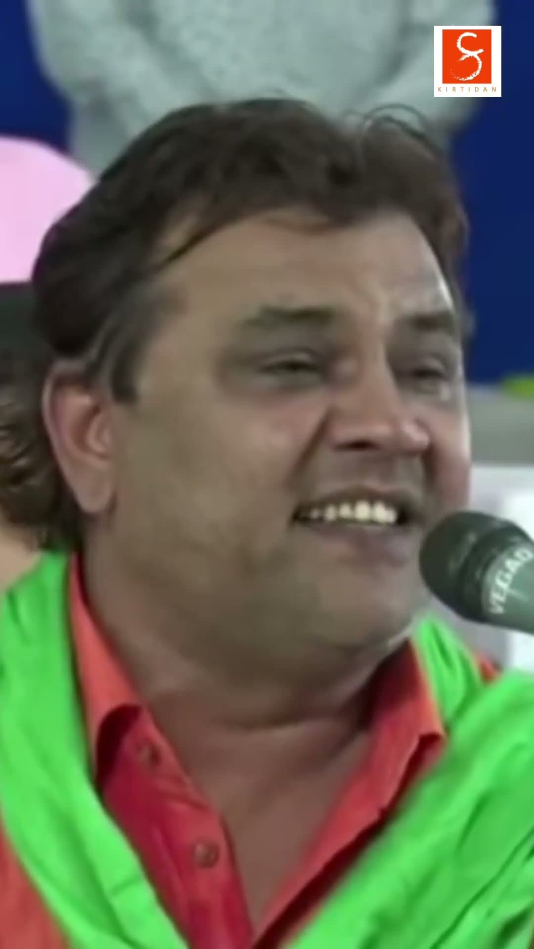 Kirtidan Gadhvi smiling mid-song